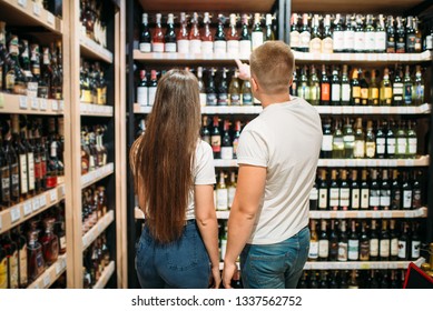 Young Couple Looking For Wine In Alcohol Market