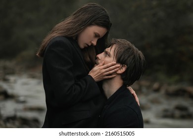 A young couple in love in black coats walks in the countryside in the rain. Autumn gloomy mood. Cinematic image - Powered by Shutterstock