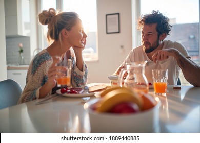 A young couple in love chatting while having a breakfast at home on a beautiful sunny morning. Relationship, love, together, breakfast - Powered by Shutterstock