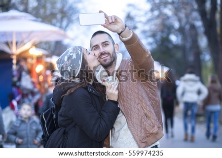 Similar – couple taking selfie in the street