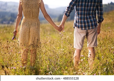 Young Couple In Love  Dressed In Country Style Standing On Field Of Flowers