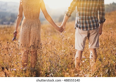 Young Couple In Love  Dressed In Country Style Standing On Field Of Flowers