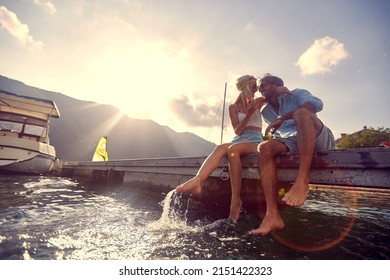 A young couple in love enjoying the water while sitting at the dock on a beautiful sunny day on the seaside. Love, relationship, holiday, sea - Powered by Shutterstock