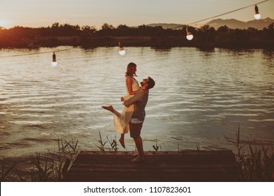 Young couple in love flirting by the river at sunset - Powered by Shutterstock