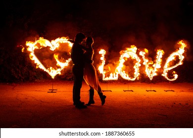 Young Couple In Love Have Fun Near Burning Fire Letters Love And Heart