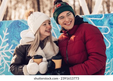 Young couple in love have fun, active date ice skating on the ice arena on a winter day.Laughing teenagers relax on a bench,drink hot cocoa,talk.Winter entertainment,leisure activity,Valentine's day. - Powered by Shutterstock