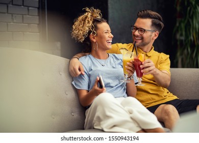 Young couple in love having fun while toasting with cocktails and celebrating in a cafe.  - Powered by Shutterstock