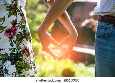 Young Couple In Love Holding Hands In The Sunset In Summer Evening. Bright Toning Picture