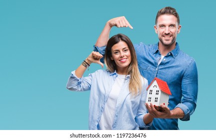 Young Couple In Love Holding House Over Isolated Background With Surprise Face Pointing Finger To Himself