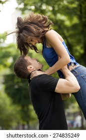 Young couple in love, hugging, she is jumping,he is holding her in embrace
