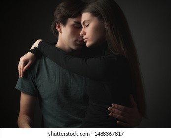 Young couple in love hugging in studio.