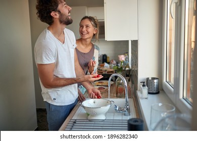 A young couple in love joking while preparing a breakfast together on a beautiful morning. Relationship, together, kitchen, love - Powered by Shutterstock