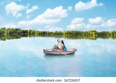 Young Couple In Love Kisses On Boat On Lake