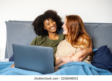 Young couple in love, lgbt couple using laptop while lying in bed for watching content on line, valentines day and lgbt people concept - Powered by Shutterstock