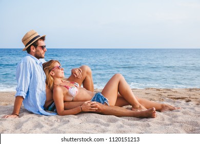 Young couple in love lying on the beach enjoying