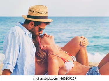 Young couple in love lying on the beach enjoying 