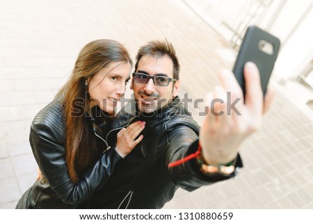 Similar – couple taking selfie in the street