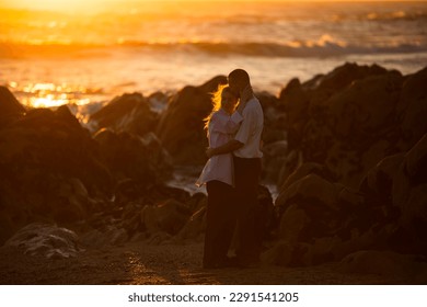 A young couple in love on the oceanfront during a golden sunset.  - Powered by Shutterstock