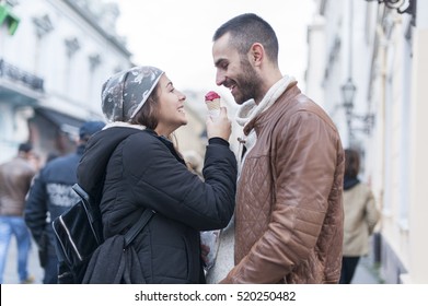 Young couple in love on the street eating ice cream and cookie
