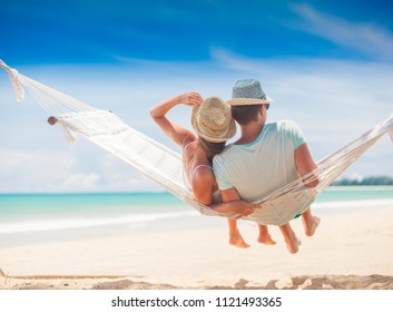 Young couple in love relaxing in a hammock by the beach - Powered by Shutterstock