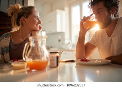 A young couple in love relaxing at the table after breakfast on a beautiful sunny morning at home. Relationship, love, together, breakfast - Shutterstock ID 1896282337