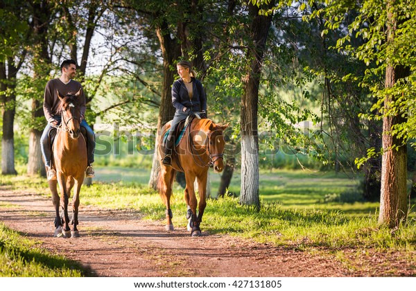 Young couple in love riding\
a horse