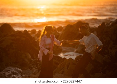 A young couple in love romantic dancing on a on the oceanfront during an amazing sunset.  - Powered by Shutterstock