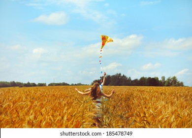 Young couple in love running with a kite in a yellow box - Powered by Shutterstock