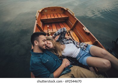 young couple in love sitting in a small boat and having fun.