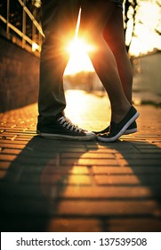 Jovem casal apaixonado de pé na rua em gumshoes no verão ensolarado clima quente.