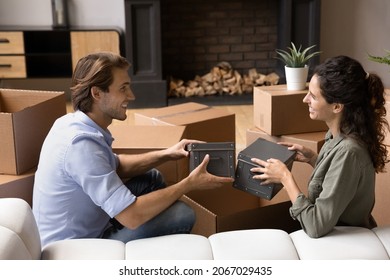 Young couple in love unpack belongings sit on sofa in their new house at relocation day, enjoy life changes, start living together. Cohabitation, bank loan, happy homeowners family, moving concept - Shutterstock ID 2067029435