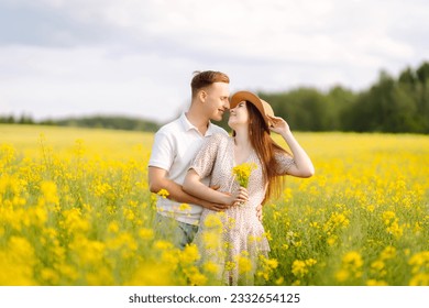 Young couple in love walks through a rapeseed field. Happy men and women in style enjoy the time spent together. The concept of love, test, relationship. - Powered by Shutterstock