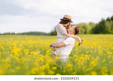 Young couple in love walks through a rapeseed field. Happy men and women in style enjoy the time spent together. The concept of love, test, relationship. - Powered by Shutterstock