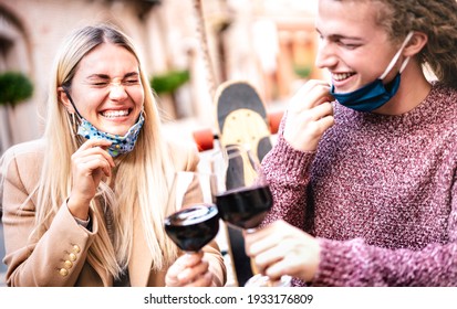 Young Couple In Love Wearing Open Face Masks And Having Fun At Winery Bar Outdoors - Happy Hipster Lovers Toasting Wine At Restaurant Patio - New Normal Relationship Concept On Bright Pastel Filter