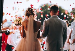 Young Couple In Love.Wedding Photo.Rose Petals Over A Couple In Love.Wedding Ceremony With Flowers