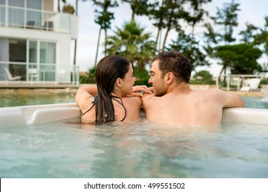 Young couple in a luxury hotel inside a jacuzzi enjoying the holidays
