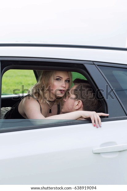 Young Couple Lying in Back\
Seat