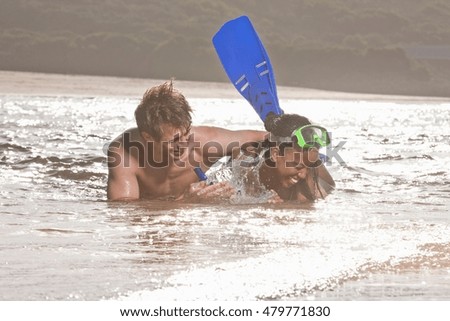 Young couple lying in sea, wearing snorkel