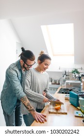 Young Couple Making Breakfast And Having Fun