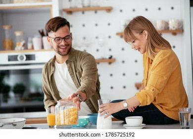 Young couple making breakfast at home. Loving couple having fun in kitchen. - Shutterstock ID 1785725192