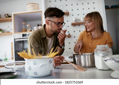 Young Couple Making Delicious Food At Home. Loving Couple Enjoying In The Kitchen.