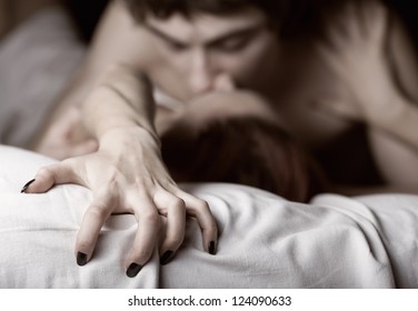 Young couple making love in bed. Focus on hand