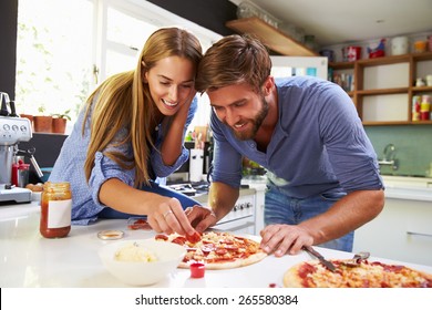 Young Couple Making Pizza In Kitchen Together - Powered by Shutterstock