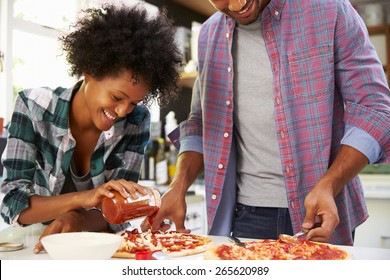 Young Couple Making Pizza In Kitchen Together