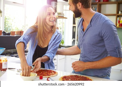 Young Couple Making Pizza In Kitchen Together - Powered by Shutterstock