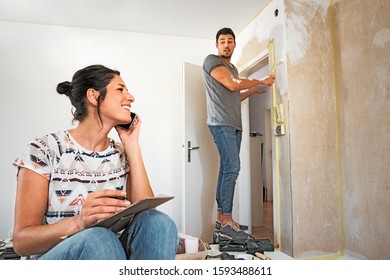 Young Couple Making Plans While Renovating The New Dwelling, Pho