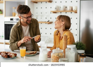 Young Couple Making Sandwich At Home. Loving Couple Enjoying In The Kitchen