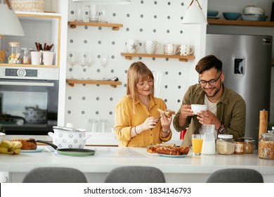 Young Couple Making Sandwich At Home. Loving Couple Enjoying In The Kitchen