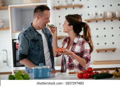 Young Couple Making Sandwich At Home. Loving Couple Enjoying In The Kitchen.