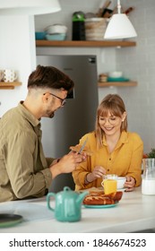 Young Couple Making Sandwich At Home. Loving Couple Enjoying In The Kitchen.	